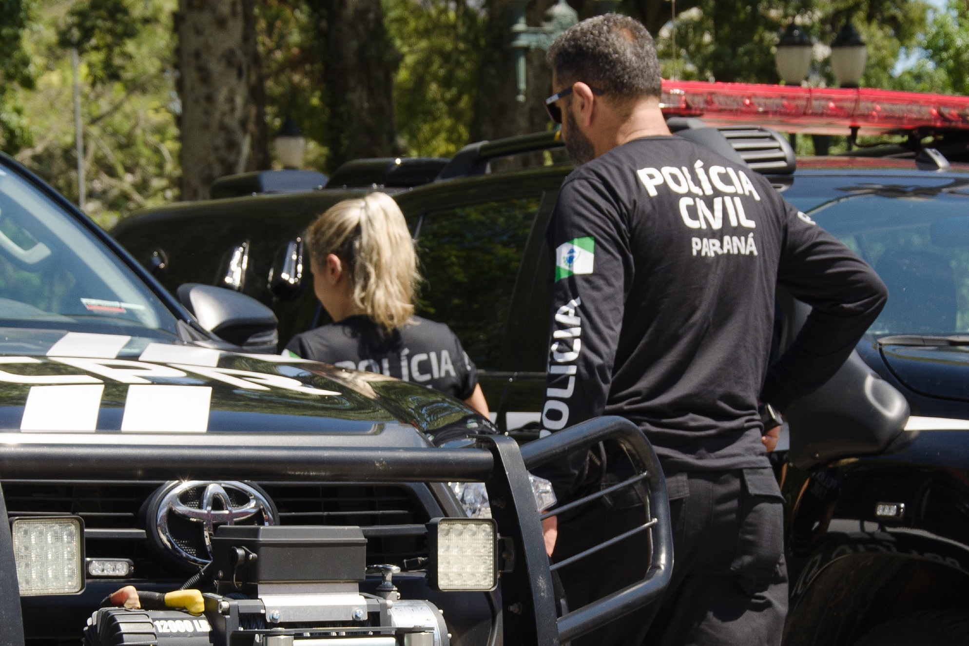 Policiais civis do Paraná ao lado de viaturas oficiais em fotografia institucional utilizada na divulgação da conclusão da investigação de quatro homicídios em Icaraíma.