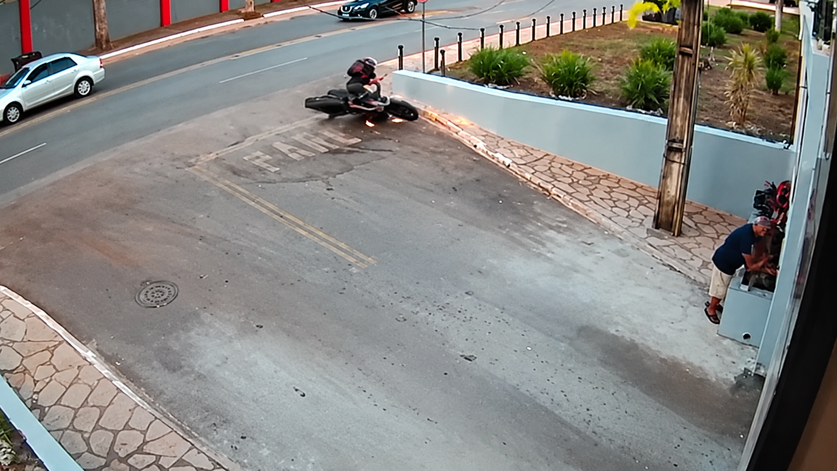 Imagem de câmera de segurança editada mostrando motocicleta próxima a uma mureta na Vila Barigui, na CIC.