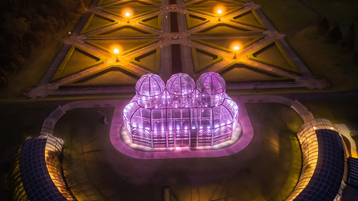 Jardim Botânico de Curitiba iluminado em lilás durante campanha de conscientização sobre Alzheimer.