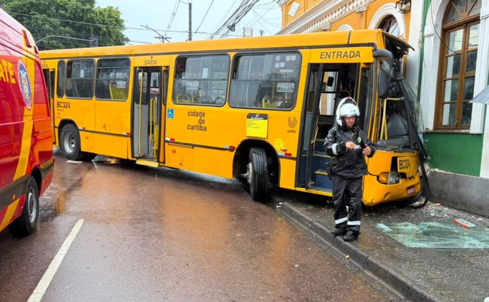 Ônibus do transporte coletivo de Curitiba após colisão contra imóvel no bairro São Francisco, com equipe de emergência no local.