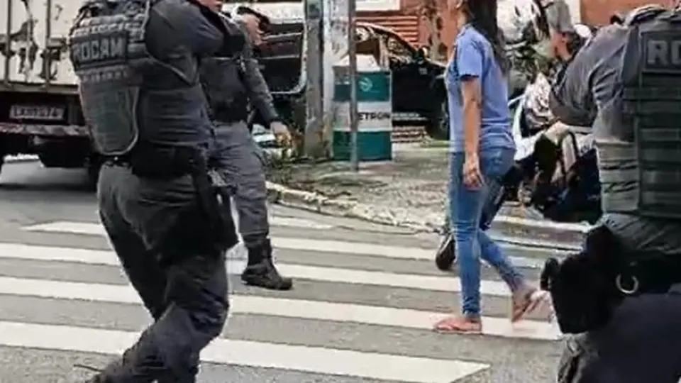 Policiais militares durante abordagem a uma mulher em uma rua de São Paulo.