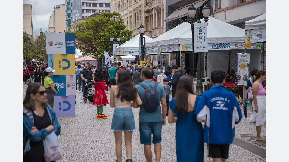 Visitantes circulam entre tendas do Domingo no Centro na Rua XV de Novembro, em Curitiba