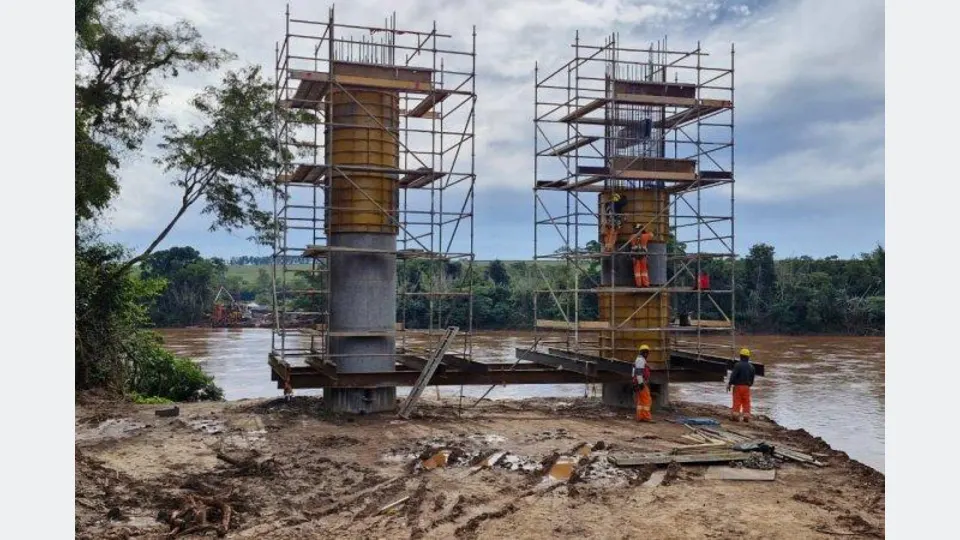 Pilares de concreto e equipamentos de construção no canteiro da nova ponte sobre o Rio Ivaí, no Noroeste do Paraná.
