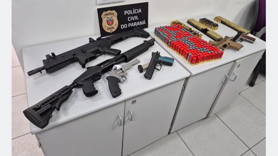 Armas de fogo, incluindo pistolas, revólver e armas longas, além de munições de diferentes calibres, apreendidas pela Polícia Civil durante investigação de violência doméstica em Curitiba.