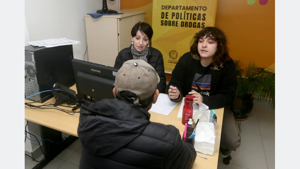 Profissionais atendem uma pessoa durante triagem do programa Base para acolhimento voluntário relacionado à dependência química em Curitiba.