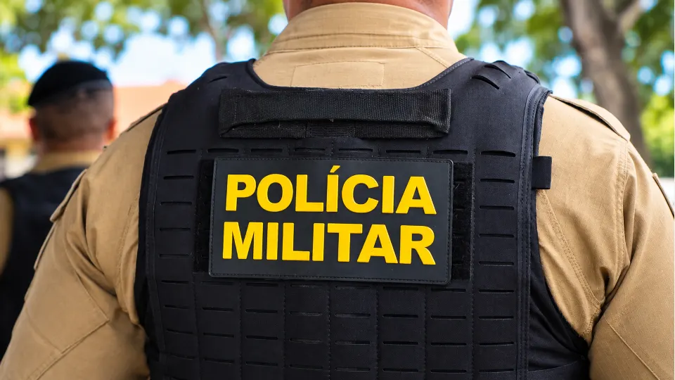 Costas de policial militar com colete identificado pela Polícia Militar, em imagem ilustrativa usada em matéria sobre ocorrência no bairro Parolin, em Curitiba.
