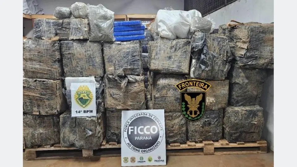 Fardos de maconha empilhados sobre paletes, acompanhados das identificações do 14º BPM, FICCO Paraná e forças policiais de fronteira.