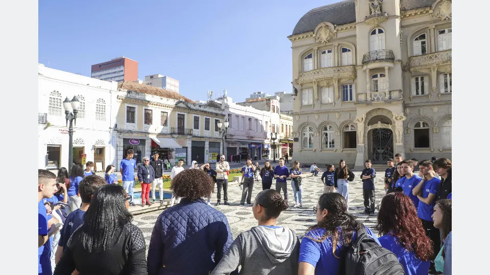 Estudantes participam de caminhada educativa da Rota Afro Curitibana pelo Centro Histórico, acompanhados por Daniele Purcino.