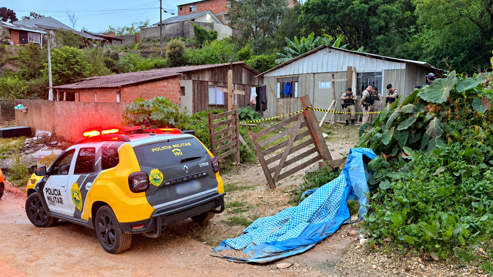 Viatura da Polícia Militar do Paraná com luzes de emergência acionadas, em frente a uma residência isolada com fita de segurança, enquanto policiais trabalham no local.