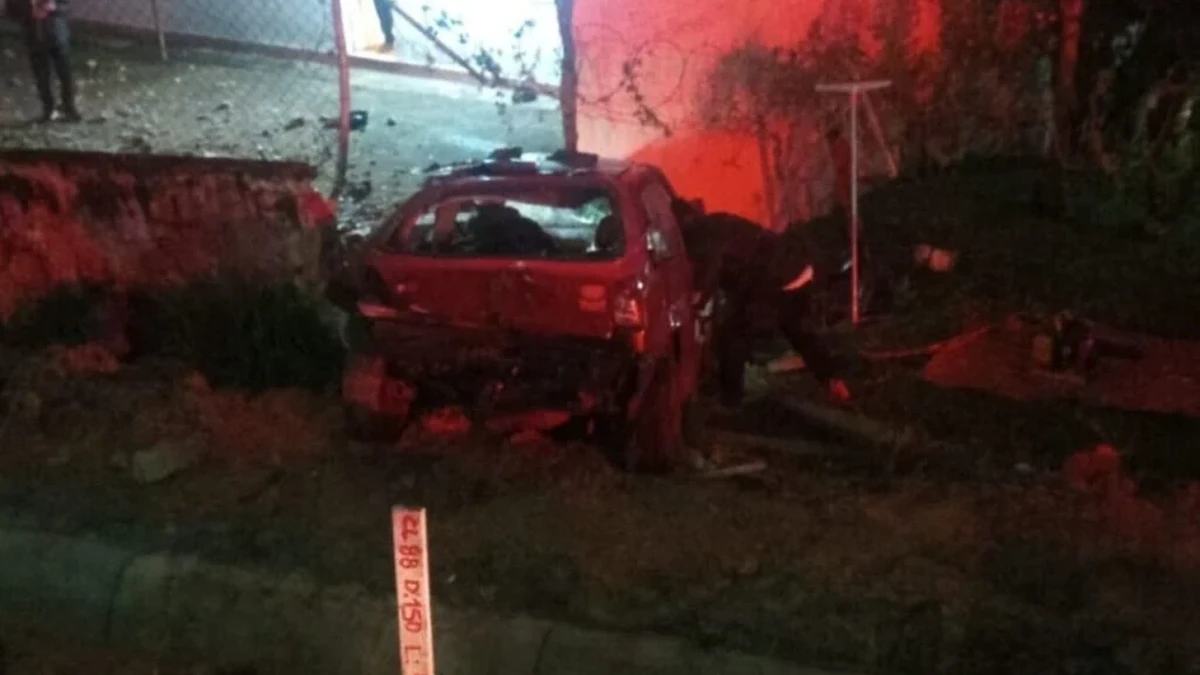 Carro com a traseira destruída próximo a um muro, durante a noite, em imagem apresentada como registro do grave acidente na BR-277, em Curitiba.