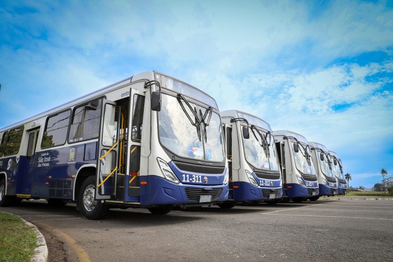 Ônibus do transporte coletivo de São José dos Pinhais estacionados em sequência.